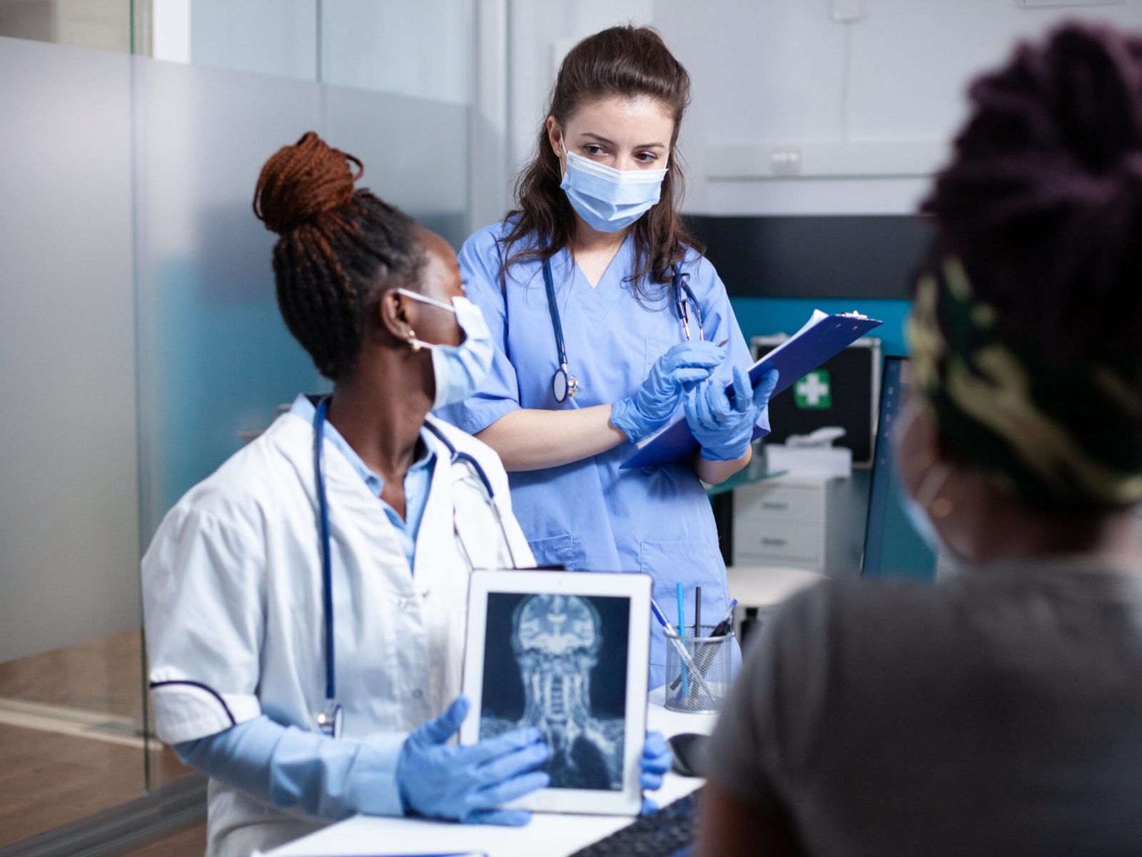 Doctor and nurse discussing treatment Doctor discussing x-ray ct scan patient cervical spine injury diagnosis results and treatment with nurse during medical appointment. Radiology medical exam in sterile antibacterial clinic environment